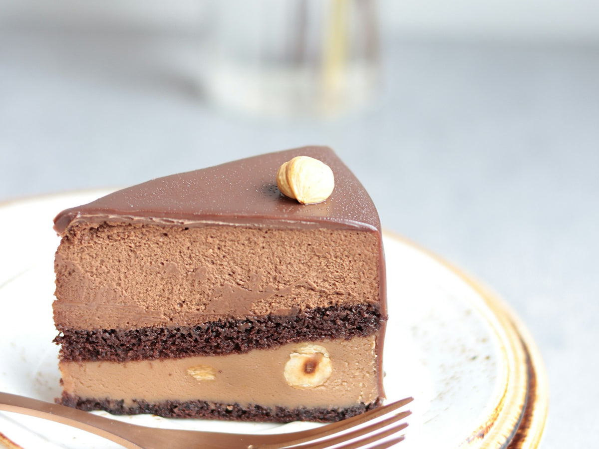 Part de gâteau mousse au praliné et chocolat avec une noisette