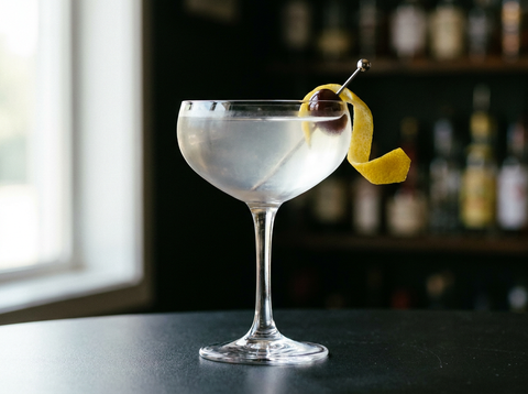 Tuxedo, cocktail classique au gin servi en verre à cocktail avec une cerise et un zeste de citron