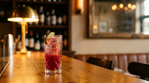 Transfusion sans alcool dans un grand verre, quartier de citron vert, comptoir de pin miel