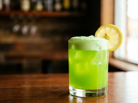 Verre coupe de Japanese Slipper, cocktail vert émeraude à la liqueur de melon et au triple sec, zeste de citron, lumière naturelle