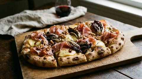 Pinsa au speck et à la scamorza ovale sur une planche en bois, blanche, scamorza fumée fondue, speck posé en vagues après cuisson, radicchio grillé, noix, bords soufflés et tachés, table de famille d'hiver, lumière chaude