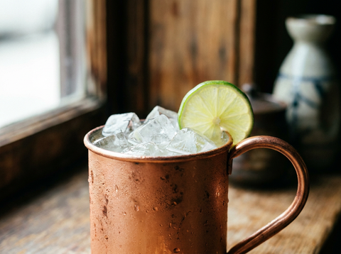 Mug de cuivre de Tokyo Mule, saké, citron vert et ginger beer sur glace, rondelle de citron vert, lumière naturelle