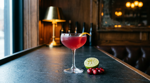 Virgin cosmopolitan en coupe, rose profond, zeste d'orange, sur un comptoir d'ardoise noire