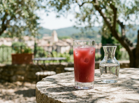 Tomate au pastis : pastis teinté de grenadine rouge sur glace, carafe d'eau, terrasse provençale