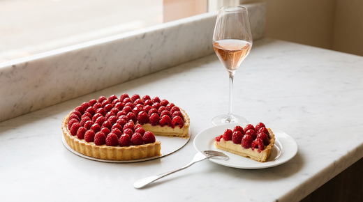 Tarte aux framboises fraîches sur crème pâtissière, part servie, verre de crémant rosé