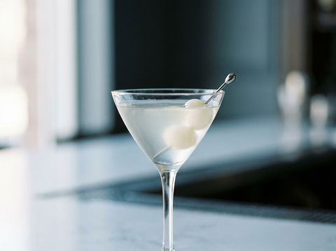 Cocktail Gibson très clair en verre à cocktail, oignons au vinaigre en garniture, lumière naturelle