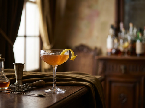 Japanese Cocktail servi en coupe cristal, robe ambrée soyeuse et zeste de citron