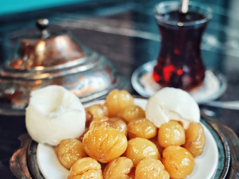 Marrons glacés brillants servis sur une assiette, avec une boule de glace