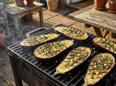 Tranches épaisses d’aubergine grillées au barbecue, chair fondante et marques de braise, avec ail, herbes et huile d’olive