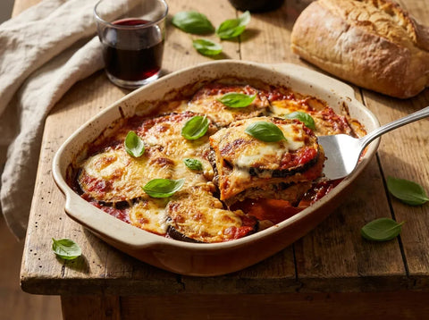 Aubergines à la parmigiana : gratin de tranches d’aubergines frites, sauce tomate, mozzarella fondante, parmesan et basilic frais