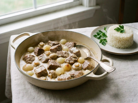 Blanquette de veau à l'ancienne, sauce ivoire soyeuse, champignons et oignons grelots, servie avec du riz pilaf