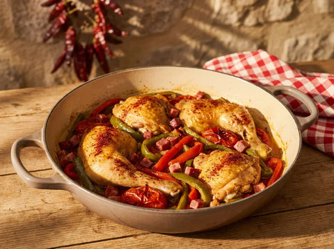 Poulet basquaise mijoté en cocotte : morceaux de poulet dorés dans une piperade de poivrons rouges et verts, tomates et piment d'Espelette