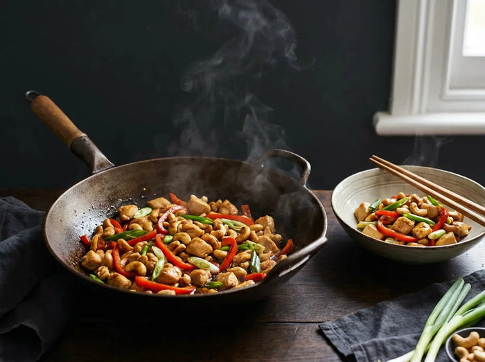 Poulet aux noix de cajou sauté au wok : dés de poulet dorés, noix de cajou, poivron rouge et oignon vert dans une sauce soja brillante