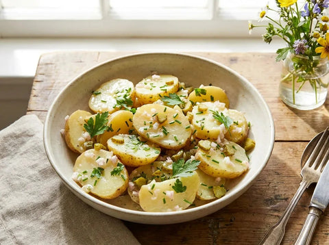 Salade de pommes de terre froide : rondelles de pommes de terre à chair ferme, échalote, cornichons et herbes fraîches dans un saladier
