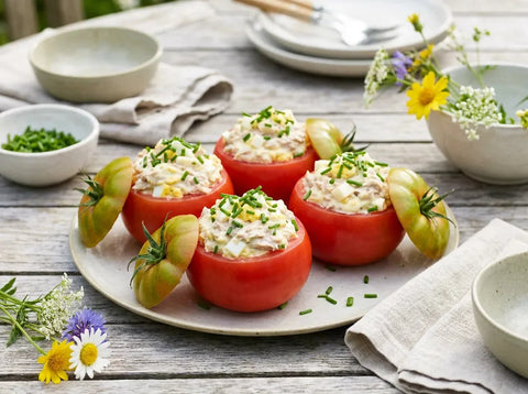 Tomates farcies froides au thon : tomates crues évidées garnies d’une farce au thon, œuf dur et mayonnaise, chapeau posé de biais