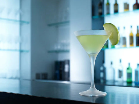 Appletini vert pâle dans un verre à martini avec une tranche de pomme verte