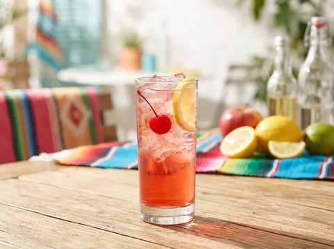 Shirley Temple, mocktail rose au ginger ale et grenadine, garni d'une cerise et d'une tranche de citron