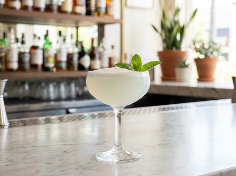 Cocktail Southside servi en coupe, garni d'une feuille de menthe fraîche