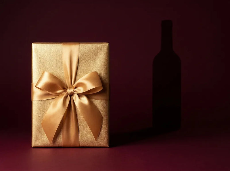 Coffret cadeau doré au ruban satin sur fond bordeaux