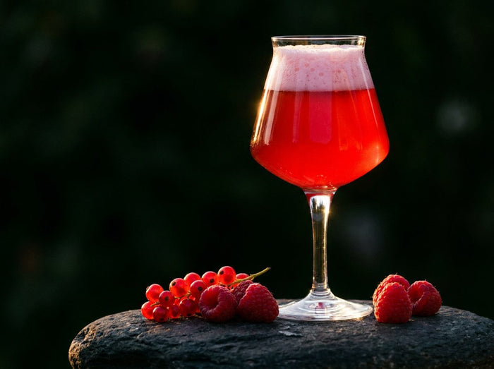 Verre de bière sour rouge framboise, framboises et groseilles fraîches