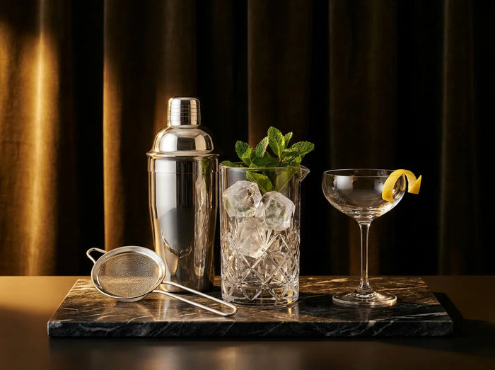 Shaker, verre à mélange et coupe sur marbre sombre